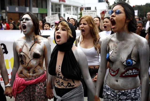 Women wearing body paint chant slogans during what organizers call a “sl*t Walk”, which they describe as a protest against the mistreatment of women, in Bogota, Colombia, on April 6, 2013. “sl*t Walks” have been held around the world, asserting that women's rights should be respected no matter their occupation, beliefs, age, or physical appearance. The protests originated in Toronto, where they were sparked by a police officer's remark that women could avoid being raped by not dressing like “sl*ts”. (Photo by Fernando Vergara/Associated Press)