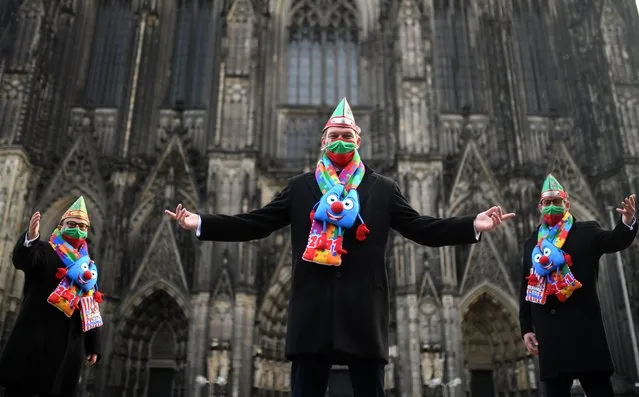 The members of the Cologne carnival triumvirate pose in front of the Cologne cathedral, western Germany, November 11, 2020. The carnival in Cologne starts usually at November 11, 11h11 but is cancelled due to the Corona Covid-19 pandemic. (Photo by Ina Fassbender/AFP Photo)