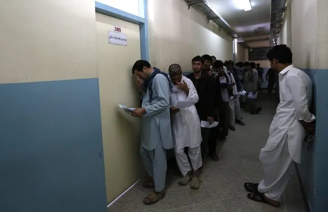 Afghan men line up as they wait for their turn to take a test before receiving a driving license at a traffic police department in Kabul August 23, 2014. (Photo by Mohammad Ismail/Reuters)