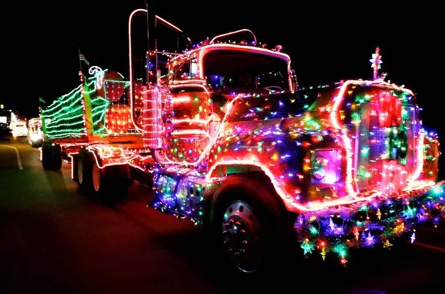 Participants in the annual Timber Truckers Light Parade head toward Myrtle Creek, Ore. from Riddle, Ore. Saturday December 13, 2014. (Photo by Michael Sullivan/AP Photos/The News-Review)