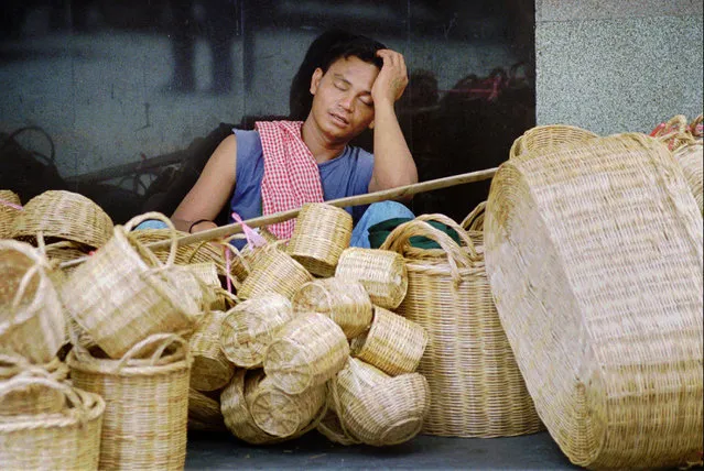 In this August 22, 1997, file photo, a street vendor takes a nap with his baskets, in Bangkok, Thailand. Asian governments and economies have recovered from the financial meltdown that spread through much of Asia 20 years ago, but many in people Thailand, the epicenter of the crisis, recall painful memories of living through it and lost everything. (Photo by Sakchai Lalit/AP Photo)