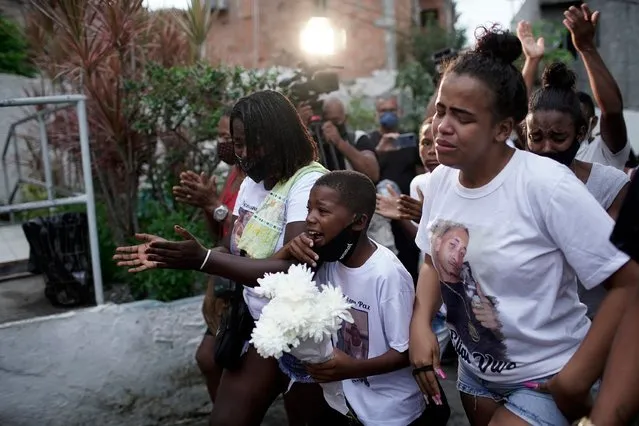 Relatives of Emily Victoria Silva dos Santos, 4, and Rebeca Beatriz Rodrigues dos Santos, 7, mourn during their burial at a cemetery in Duque de Caxias, Rio de Janeiro state, Brazil, Saturday, December 5, 2020. Grieving families held funerals for Emily and Rebeca, killed Friday night by bullets while playing outside their homes. Li­dia da Silva Moreira Santos, grandmother of Rebecca and aunt of Emily Victoria, said that when she arrived home from work around 8 p.m. on Friday she saw police shooting toward the community where the families lived. (Photo by Silvia Izquierdo/AP Photo)