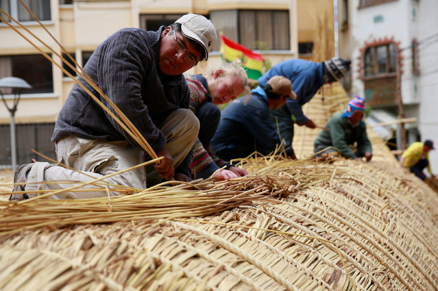 Builders work on top of the “Viracocha III”, a boat made only from the totora reed, as it is being prepared to cross the Pacific from Chile to Australia on an expected six-month journey, in La Paz, Bolivia, October 19, 2016. (Photo by David Mercado/Reuters)