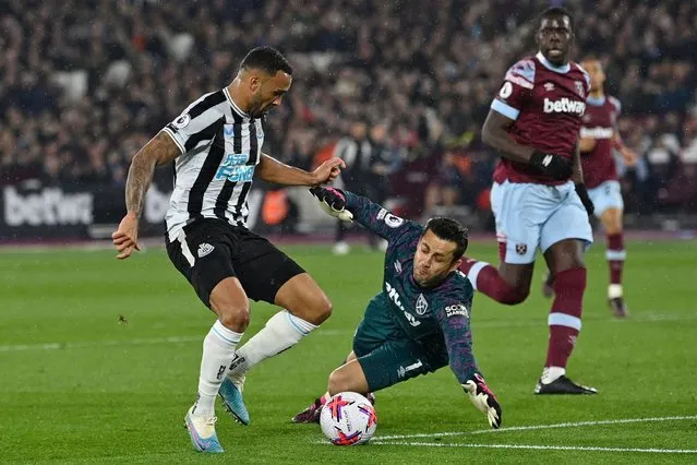 Newcastle United's English striker Callum Wilson (L) fights for the ball with West Ham United's Polish goalkeeper Lukasz Fabianski (C) during the English Premier League football match between West Ham United and Newcastle at the London Stadium, in London on April 5, 2023. (Photo by Justin Tallis/AFP Photo)