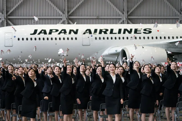 Newly hired employees for Japan Airlines (JAL) release paper airplanes during an entrance ceremony in a hangar at Haneda Airport on April 03, 2023 in Tokyo, Japan. (Photo by Tomohiro Ohsumi/Getty Images)