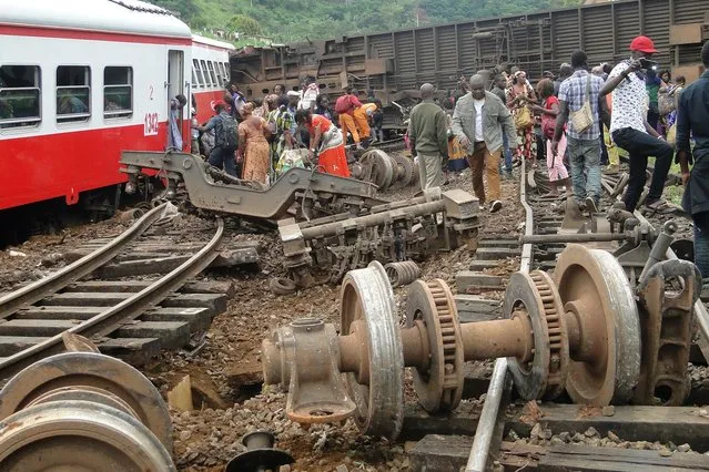 Passenger escapes the site of a train derailment in Eseka on October 21, 2016. Fifty-three were killed and over 300 injured when a packed Cameroon passenger train derailed on October 21 while travelling between the capital Yaounde and the economic hub Douala, state broadcaster Crtv said. The train, crammed with people due to road traffic disruption between the two cities, left the tracks just before reaching the central city of Eseka, Transport minister Edgar Alain Mebe Ngo'o said earlier. (Photo by AFP Photo/Stringer)