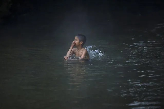 A boy takes a holy bath in the River Saali in Sankhu on the first day of Swasthani Brata Katha festival in Kathmandu January 5, 2015. (Photo by Navesh Chitrakar/Reuters)