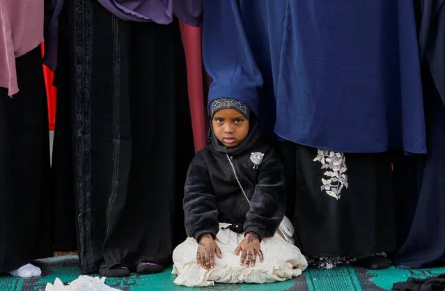 A Muslim girl sits among faithful attending Eid al-Fitr prayers, marking the end of the fasting month of Ramadan, at the Masjid Salaam grounds in Nairobi, Kenya on April 21, 2023. (Photo by Monicah Mwangi/Reuters)