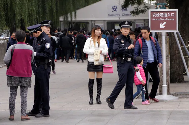 Police check tourists outside a security check entrance to Tiananmen Square on the first day of a plenary session of the 18th Central Committee of the Communist Party of China (CPC), in Beijing, China, October 24, 2016. (Photo by Jason Lee/Reuters)