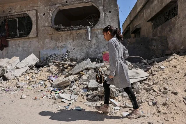A Palestinian school girl walks past a building, which was heavily damaged during fighting between Israel and Islamic Jihad militants in the beginning of May 2023, in Beit Lahia in the northen Gaza Strip, on May 31, 2023. (Photo by Mohammed Abed/AFP Photo)
