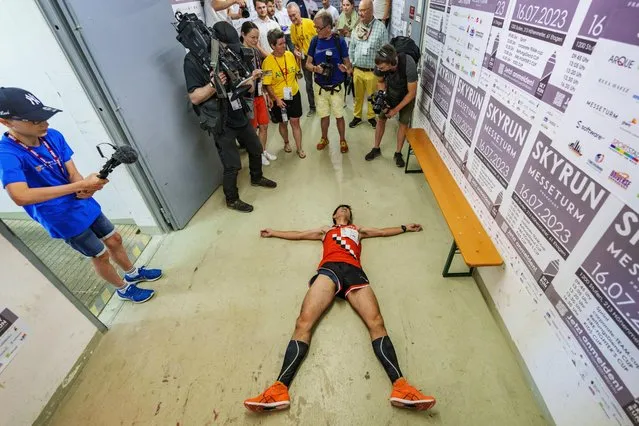 Ryoji Watanabe, world-class runner from Japan, lies exhausted on the ground in front of journalists after crossing the finish line on the 61st floor in Hesse, Frankfurt/Main on July 16, 2023. The “SkyRun MesseTurm Frankfurt” is a World Cup race and a charity stair run up to the 61st floor of the Frankfurt MesseTurm. In addition to competitive athletes, company and rescue teams, as well as fire department emergency services, also take part in the “SkyRun”. (Photo by Andreas Arnold/dpa)