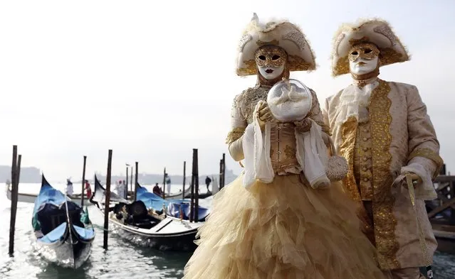 Masked revellers pose in front of St.Mark square during carnival, in Venice February 8, 2015. (Photo by Stefano Rellandini/Reuters)