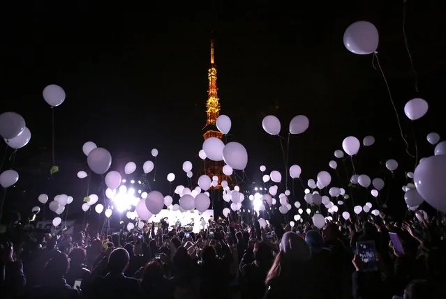 Peoples release balloons to celebrate the New Year with Tokyo Tower in the background  in Tokyo, early Friday, January 1, 2016. Japan celebrated the start of 2016, the Year of the Monkey in the Japanese Zodiac. (Photo by Eugene Hoshiko/AP Photo)