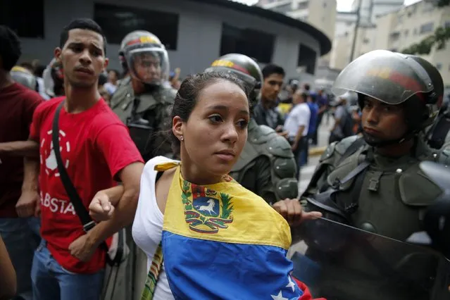 Opposition students march next to national guards during a march against President Nicolas Maduro's government in Caracas February 12, 2015. (Photo by Jorge Silva/Reuters)