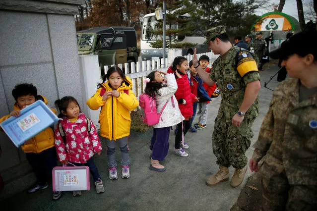 Bryan Waite, a US navy officer based in JSA area for U.N. command, high-fives children at the Daesungdong Elementary School, a school inside the demilitarised zone separating the two Koreas, in Paju, South Korea, November 22, 2016. (Photo by Kim Hong-Ji/Reuters)
