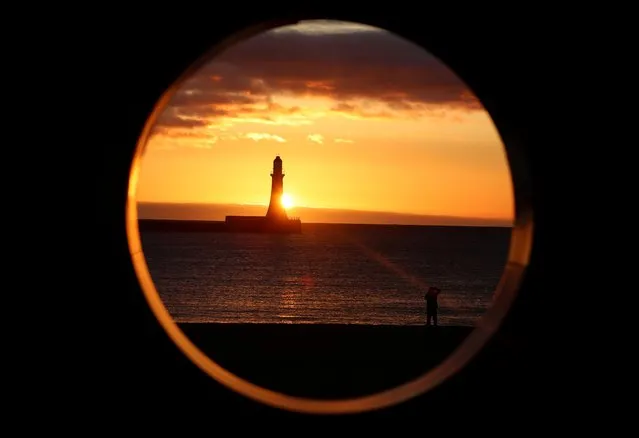 View of sunrise behind a lighthouse at Roker Beach in Sunderland, Britain on March 15, 2021. (Photo by Lee Smith/Reuters)