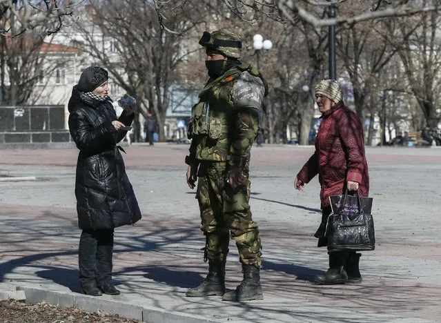 Local residents speak with a member of the Ukrainian armed forces in Artemivsk, eastern Ukraine, February 21, 2015.  REUTERS/Gleb Garanich  (UKRAINE - Tags: POLITICS CIVIL UNREST MILITARY CONFLICT SOCIETY)