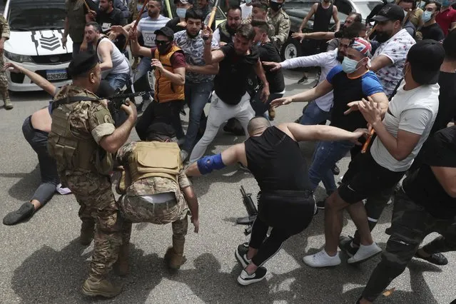 In this April 19, 2021 file photo, opponents of Judge Ghada Aoun try to strip an army soldier of his rifle as scuffles break out during a sit-in outside the Justice Palace, in Beirut, Lebanon. (Photo by Bilal Hussein/AP Photo/File)