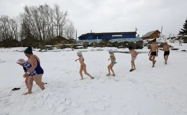 Zinaida Bulygina (2nd L), 65, leads a group of local children, members of a winter swimmers family club, after leaving a sauna before swimming in the icy waters of the Tuba river in the Kuragino village, southeast of the Russian Siberian city of Krasnoyarsk, March 17, 2015. (Photo by Ilya Naymushin/Reuters)
