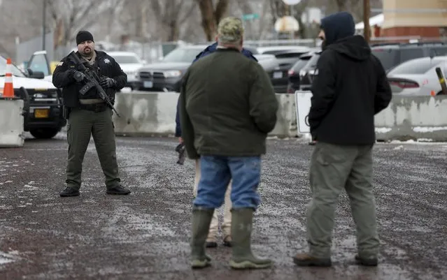 A law enforcement officer guards an entry to a complex of buildings at the Harney County Court House as a demonstration takes place, in Burns, Oregon January 29, 2016. Four armed anti-government protesters held their ground at a remote U.S. wildlife refuge in Oregon on Friday, a day after the FBI released a video of the fatal shooting of one of the group's spokesmen during a traffic stop. (Photo by Jim Urquhart/Reuters)