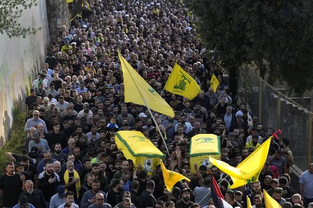 Hezbollah supporters carry the coffins of the two Hezbollah fighters who were killed by Israeli shelling, during their funeral procession in Kherbet Selem village, south Lebanon, Tuesday, October 10, 2023. The Iran-backed group Monday night announced that three militants died following heavy Israeli shelling in border towns across southern Lebanon. (Photo by Hussein Malla/AP Photo)