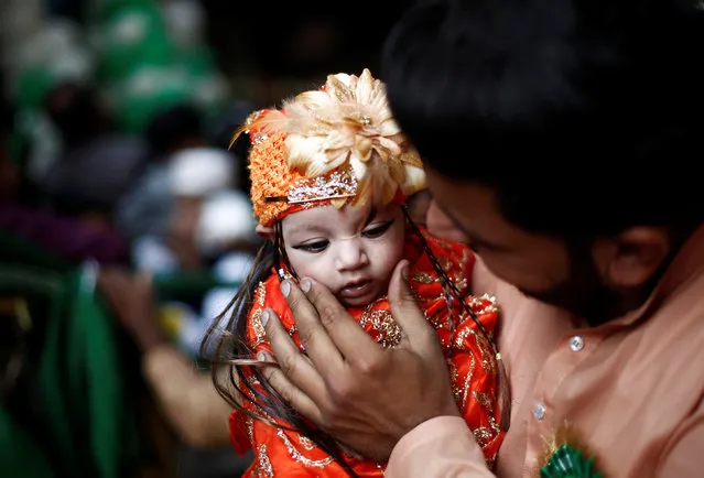 A Muslim man carries his daughter as he attends a religious procession to mark Eid-e-Milad-ul-Nabi, or birthday celebrations of Prophet Mohammad, in the old quarters of Delhi, November 21, 2018. (Photo by Adnan Abidi/Reuters)