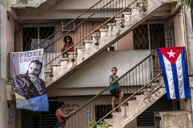 People wait to be vaccinated with the Cuban Abdala vaccine for COVID-19 at a doctors' office, decorated with an image of Fidel Castro and a Cuban flag, in the Alamar neighborhood of Havana, Cuba, Friday, May 14, 2021. (Photo by Ramon Espinosa/AP Photo)
