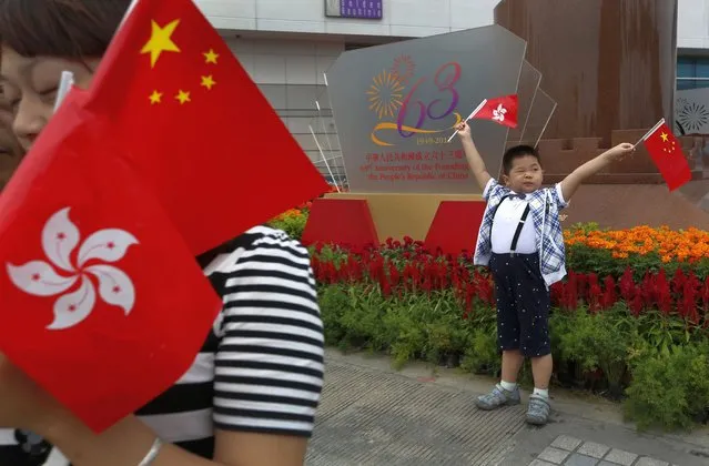 In this Monday, October 1, 2012, file photo, a children from mainland China holding flags of China and Hong Kong poses at the venue of the flag-raising ceremony for China's National Day in Hong Kong. A year after Beijing imposed a harsh national security law on Hong Kong, the civil liberties that raised hopes for more democracy are fading. (Photo by Vincent Yu/AP Photo/File)