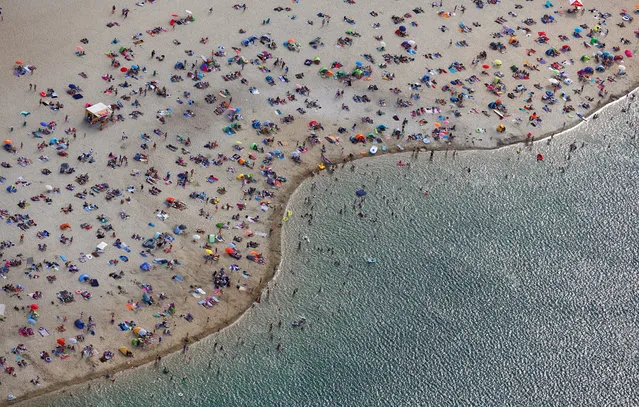 People at a beach on the shores of lake Silbersee (Silver Lake) during a long-lasting heatwave in Haltern, Germany, August 4, 2018. (Photo by Wolfgang Rattay/Reuters)