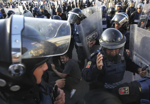 Police forcibly remove demonstrators who blocked a main road for about an hour as they protest hikes in gas prices in Mexico City, Wednesday, January 4, 2017. Protesters have blocked highways, distribution terminals and gas stations since fuel prices went up by as much as 20 percent over the weekend under a price deregulation plan. (Photo by Marco Ugarte/AP Photo)