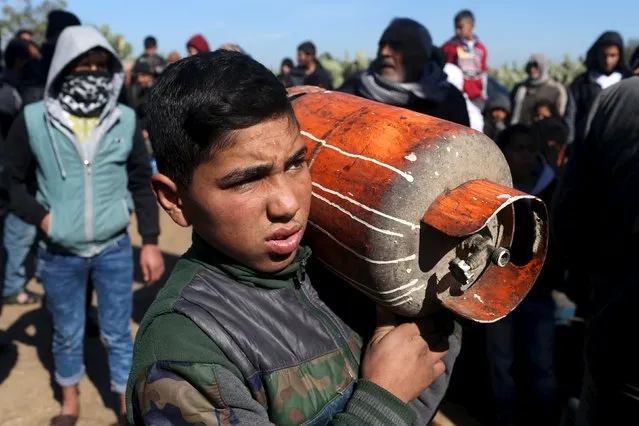 A Palestinian boy carries an empty gas canister as he waits to fill it outside a gas filling station in Rafah in the southern Gaza Strip January 28, 2016. The strip, home for 1.95 million people, has been experiencing a shortage of cooking gas, local residents said. (Photo by Ibraheem Abu Mustafa/Reuters)