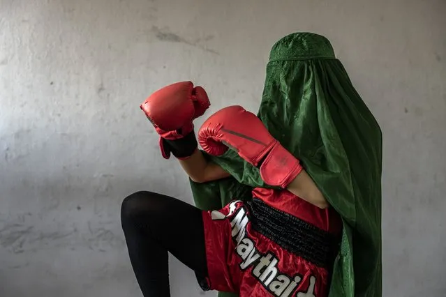 An Afghan woman who practices Muay Tha, or Thai boxing, poses for a photo in Kabul, Afghanistan, Saturday, October 29, 2022. The ruling Taliban have banned women from sports as well as barring them from most schooling and many realms of work. A number of women posed for an AP photographer for portraits with the equipment of the sports they loved. Though they do not necessarily wear the burqa in regular life, they chose to hide their identities with their burqas because they fear Taliban reprisals and because some of them continue to practice their sports in secret. (Photo by Ebrahim Noroozi/AP Photo)