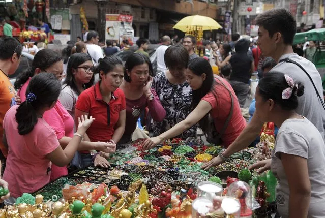 Residents buy lucky charm along a sidewalk on the eve of Chinese new year in Manila Chinatown, Philippines February 7, 2016. (Photo by Janis Alano/Reuters)