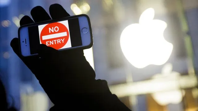 A man holds up an iPhone with a “No Entry” graphic as part of a rally in front of an Apple Store in support of the company's privacy policy, in New York, New York, USA, 23 February 2016. Apple is currently in a legal dispute with the FBI, which has requested that Apple unlock the iPhone of one of the people involved in the San Bernardino terrorist attacks. (Photo by Justin Lane/EPA)