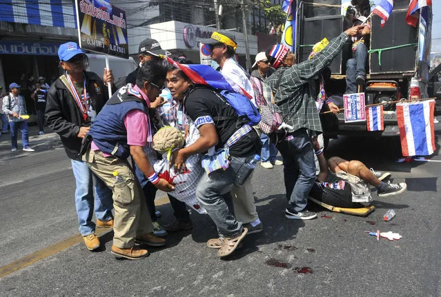 Anti-government protesters help a fellow protester injured in a grenade attack during a rally in Bangkok January 17, 2014. (Photo by Reuters/Stringer)