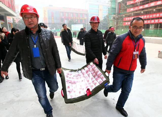 Staff prepare to give out salary and bonus to migrant workers ahead of the Spring Festival at a construction site in Xi'an, Shaanxi province, China, Janauary 18, 2017. (Photo by Reuters/Stringer)