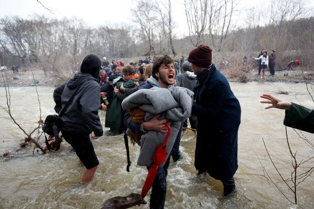 Migrants try to cross a river after leaving  the Idomeni refugee camp on March 13, 2016 in Idomeni, Greece. (Photo by Matt Cardy/Getty Images)