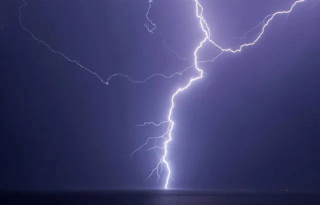 A lightning strikes the sea, as seen from the town of Neos Marmaras, Greece, July 2, 2021. (Photo by Dimitar Kyosemarliev/Reuters)