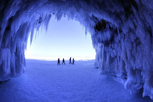 In this February 2, 2014 photo people visit the caves at  Apostle Islands National Lakeshore in northern Wisconsin, transformed into a dazzling display of ice sculptures by the arctic siege gripping the Upper Midwest. (Photo by Brian Peterson/AP Photo/Minneapolis Star Tribune)