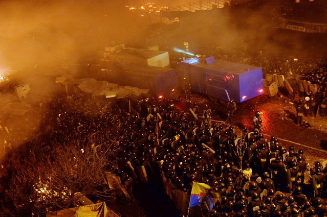 Anti-government protesters clash with the police during their storming of Independence Square in Kiev on February 18, 2014. Flames engulfed the main anti-government protest camp on  Independence Square on Tuesday as riot police tried to force demonstrators out following the bloodiest clashes in three months of protests. (Photo by Sergei Supinsky/AFP Photo)