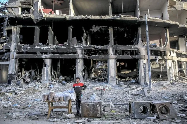 A Palestinian vendor waits for customers in front of a building destroyed by Israeli bombardment in Gaza City on March 3, 2024, amid the ongoing conflict between Israel and the Hamas movement. (Photo by AFP Photo)