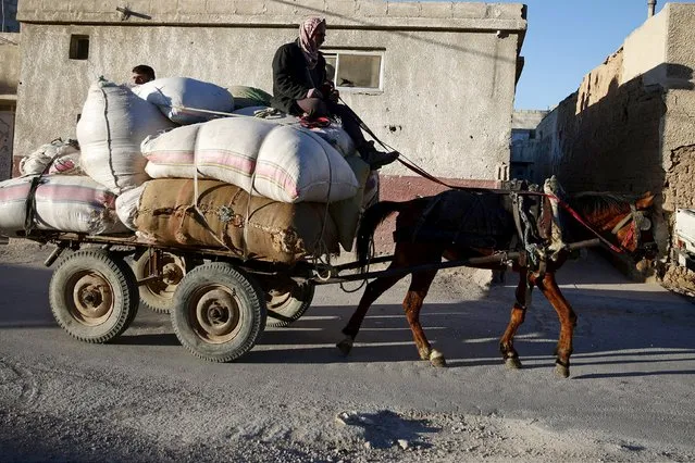 A man rides on a cart pulled by a horse along a street in the rebel-held Douma neighborhood of Damascus, Syria March 20, 2016. (Photo by Bassam Khabieh/Reuters)