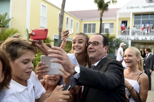 France's President Francois Hollande takes a picture with students in Saint Barthelemy on May 8, 2015, as part of a five days visit to the Caribbean including Guadeloupe, Martinique, Cuba and Haiti. (Photo by Alain Jocard/AFP Photo)