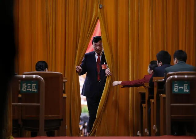 A man opens a curtains inside the Great Hall of the People at Tiananmen Square during the opening session of the National People's Congress (NPC) in Beijing March 5, 2014. (Photo by Kim Kyung-Hoon/Reuters)