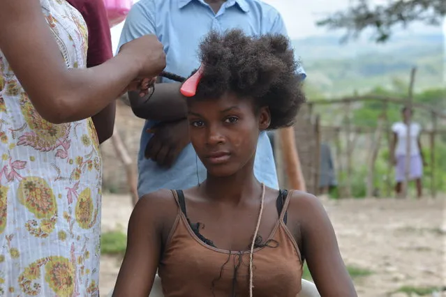In this March 22, 2015 photo, 21-year-old Itania Auguste gets her hair done at an encampment outside the southeast Haitian town of Anse-a-Pitres, Haiti. (Photo by David McFadden/AP Photo)