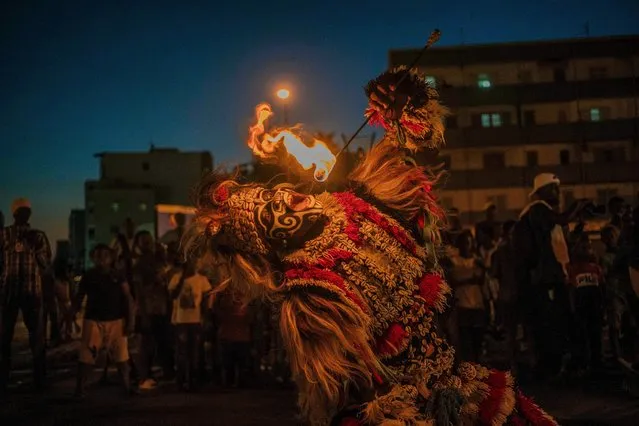A fire-eater man dressed as a lion participates in the Grand Carnival parade in Dakar on November 27, 2021. Created in 2019, this annual event celebrates the cultural and ethnic diversity of Senegal. (Photo by Carmen Abd Ali/AFP Photo) 