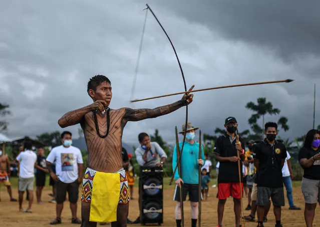 A Panamanian Embera indigenous competes in bow and arrow during the third ancestral indigenous games in Pueblo Nuevo Buri, province of Bocas del Toro, Panama on December 16, 2021. At least 250 indigenous from Panama's seven ethnic groups are fighting not only to win a medal in the Ancestral Indigenous Games, but also to rescue and perpetuate the customs and traditions of their communities. (Photo by Luis Acosta/AFP Photo)