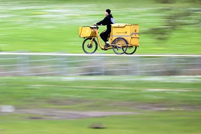 German postal service Deutsche post employee rides a bicycle in Frankfurt am Main, western Germany, on March 27, 2024. (Photo by Kirill Kudryavtsev/AFP Photo)