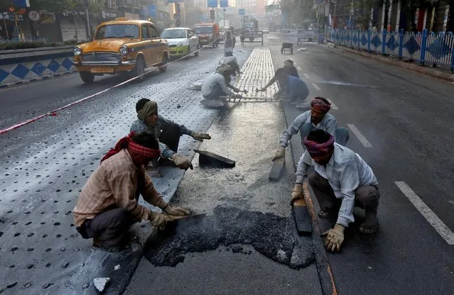 Labourers work at a road construction site early morning in Kolkata, India February 27, 2017. (Photo by Rupak De Chowdhuri/Reuters)