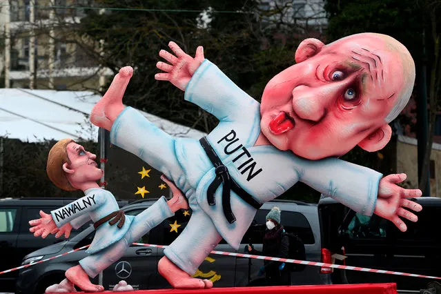 A carnival float depicting Russian opposition leader Alexei Navalny (L) dressed as a judoka kicking the balls of Russian President Vladimir Putin is seen during a slimmed down version of the traditional Rose Monday parade on February 15, 2021 in Duesseldorf, western Germany. Due to the novel coronavirus COVID-19 pandemic, traditional parades and festivities in Germany's carnival hotspots, mainly situated in the Rhineland region, had to be canceled or modified to conform to the rules and restrictions in order to limit the spread of the virus. (Photo by Ina Fassbender/AFP Photo)